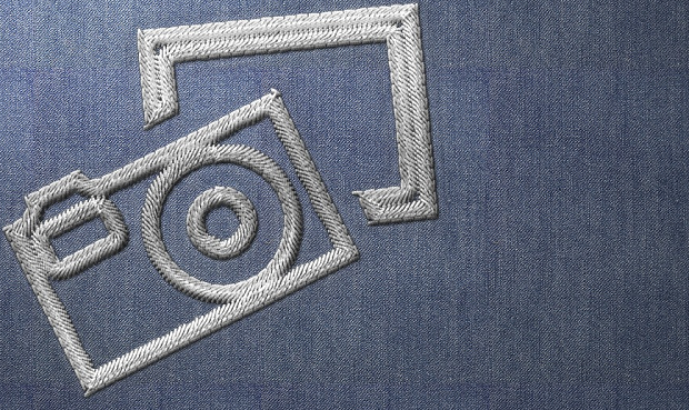 An image of a camera stitched into blue fabric